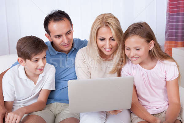 Familia feliz usando la computadora portátil dos ninos sesión sofá Foto stock © AndreyPopov