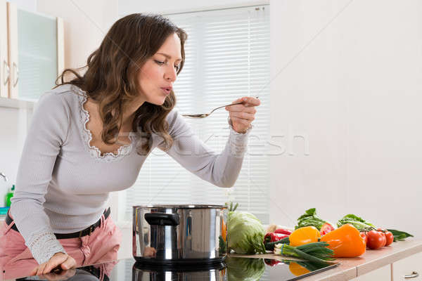 Jonge vrouw proeverij voedsel lepel keuken meisje Stockfoto © AndreyPopov