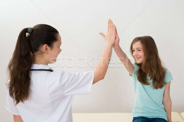 Lekarza high five dziewczyna młodych kobiet kliniki Zdjęcia stock © AndreyPopov
