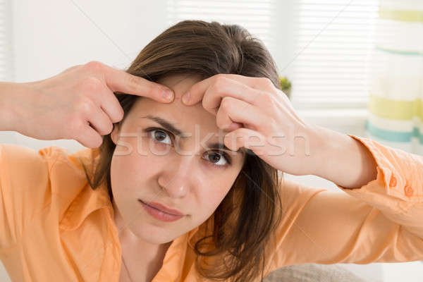 Stock photo: Woman Squeezing Pimple
