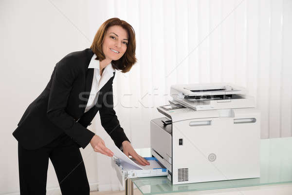 Businesswoman Inserting Papers In Photocopy Machine Stock photo © AndreyPopov