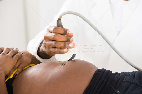 Doctor's Hand Moving Ultrasound On Pregnant Woman's Belly Stock photo © AndreyPopov
