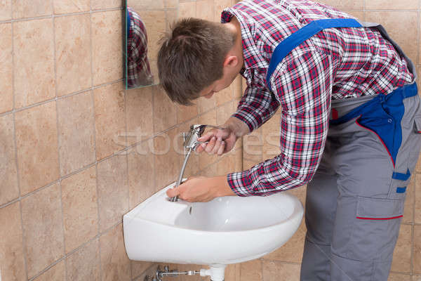 Stock fotó: Vízvezetékszerelő · megjavít · csap · mosdókagyló · fiatal · férfi