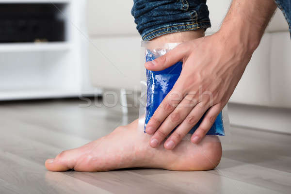 Person's Hand Holding Ice Gel Pack On Ankle Stock photo © AndreyPopov