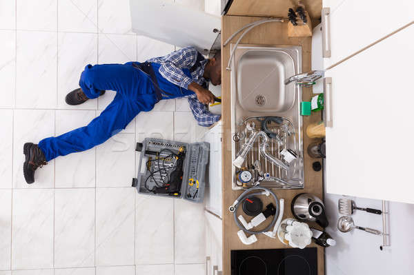 Handyman Lying On Floor Repairing Sink Stock photo © AndreyPopov