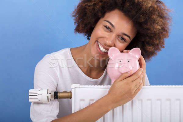 Kobieta za ogrzewania radiator banku piggy Zdjęcia stock © AndreyPopov