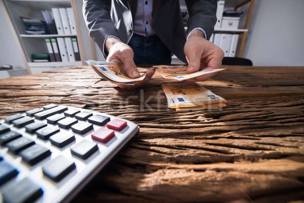 Businessperson's Hand Counting Banknotes Stock photo © AndreyPopov