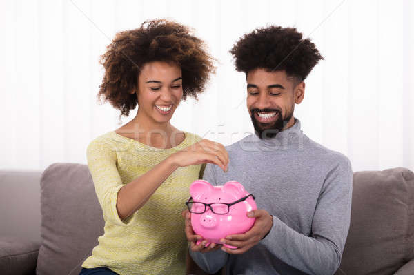 Couple Inserting Coin In Piggybank Stock photo © AndreyPopov