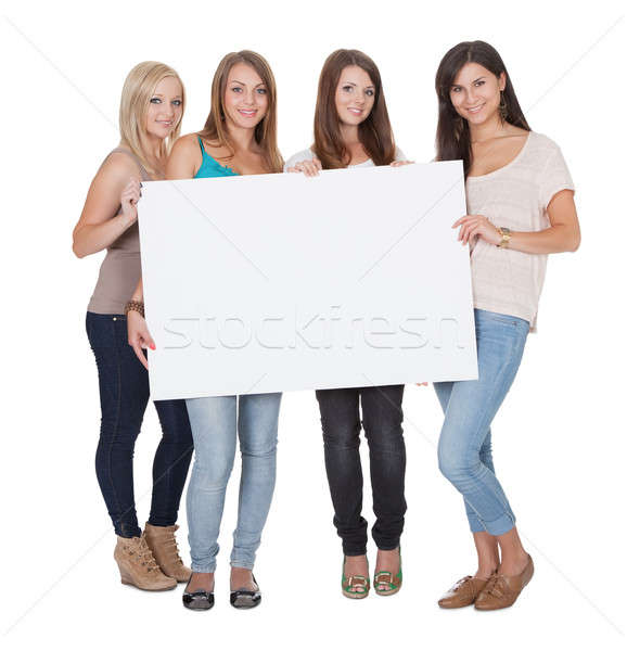 Four attractive girls holding a white board Stock photo © AndreyPopov