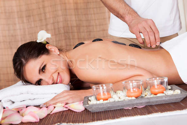Beautiful young woman getting hot stone therapy Stock photo © AndreyPopov