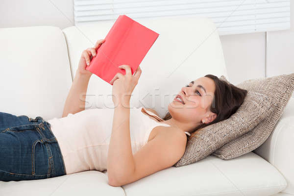 Foto stock: Mujer · sonriente · lectura · libro · sofá · hermosa