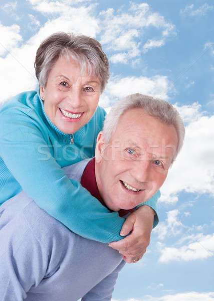 Senior om piggyback femeie cer portret Imagine de stoc © AndreyPopov