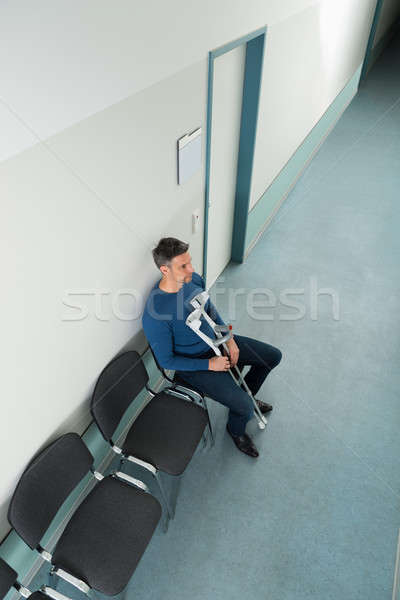Człowiek posiedzenia krzesło kule kalekiego widoku Zdjęcia stock © AndreyPopov