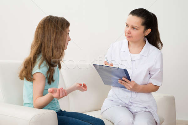 Doctor And Patient With Clipboard On Sofa Stock photo © AndreyPopov