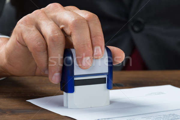 Businessman Stamping Document At Desk Stock photo © AndreyPopov