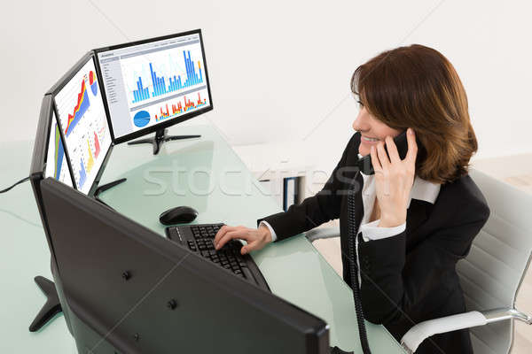 Femeie de afaceri grafice multiplu Calculatoare vorbesc telefon Imagine de stoc © AndreyPopov