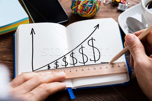 Person Hand Drawing Dollar Growth Chart On Notebook Stock photo © AndreyPopov