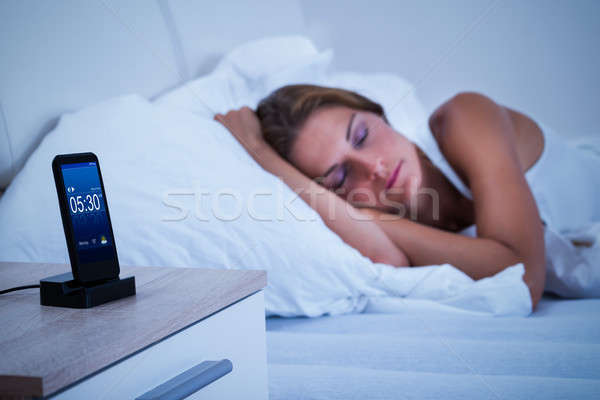 Sleeping Woman With Mobile Alarm Clock Stock photo © AndreyPopov