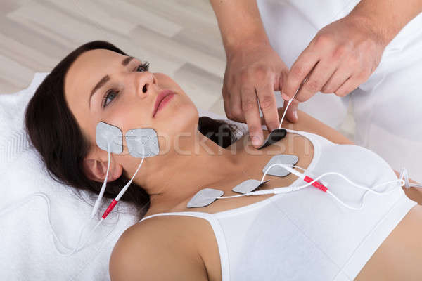 Therapist Placing Electrodes On Woman's Chest Stock photo © AndreyPopov