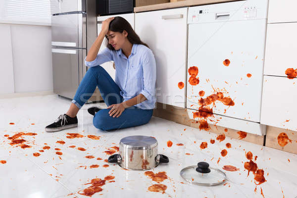 Woman Sitting On Kitchen Floor With Spilled Food Stock photo © AndreyPopov