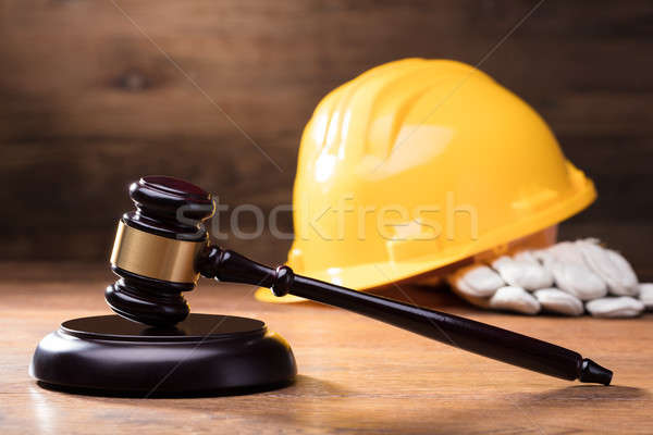 Gavel In Front Of Yellow Safety Helmet Stock photo © AndreyPopov