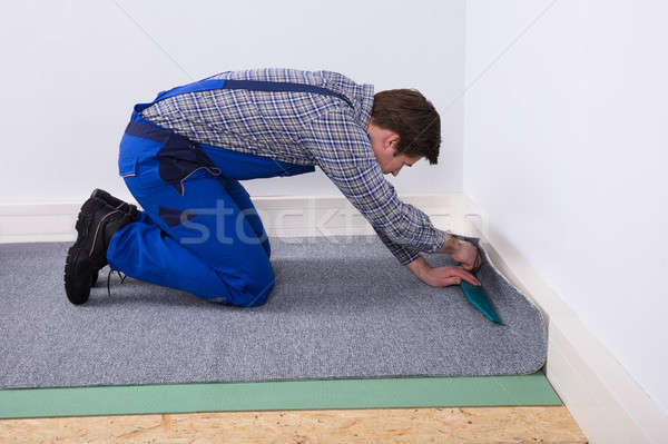 Worker Fitting Carpet On Floor Stock photo © AndreyPopov
