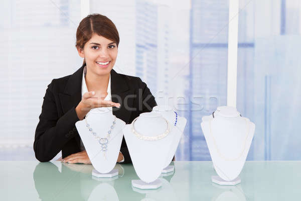 Confident Saleswoman Displaying Jewelry At Desk Stock photo © AndreyPopov