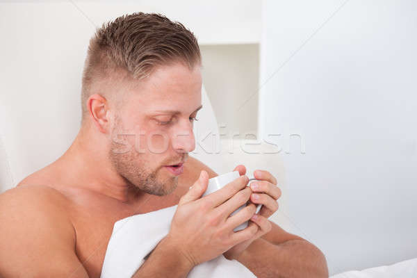 Man drinking hot tea in bed Stock photo © AndreyPopov