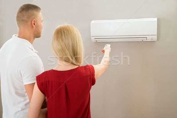 Foto stock: Pareja · temperatura · acondicionador · de · aire · control · remoto · casa