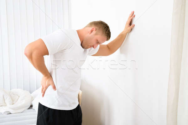 Young Man Having Pain In His Back Stock photo © AndreyPopov