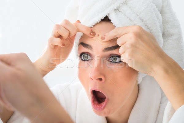 Shocked Woman Looking At Pimple On Forehead Stock photo © AndreyPopov