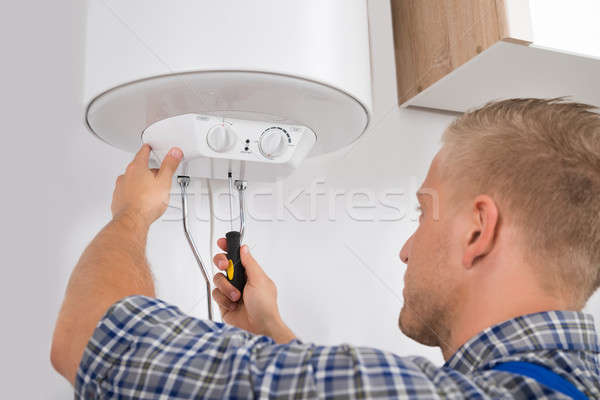 Worker Fixing Electric Boiler Stock photo © AndreyPopov