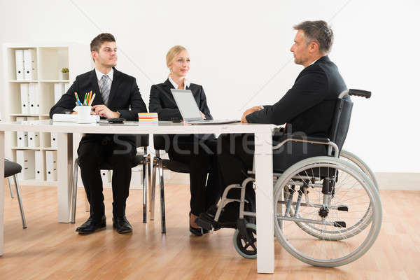 Mozgássérült üzletember megbeszél munkatársak érett iroda Stock fotó © AndreyPopov