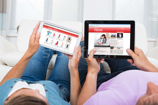 Couple Online Shopping And Reading News On Digital Tablets Stock photo © AndreyPopov