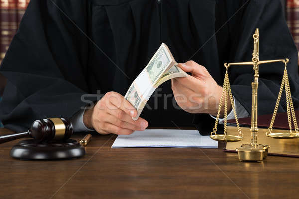 Corrupt Judge Holding Dollar Bundle At Desk Stock photo © AndreyPopov