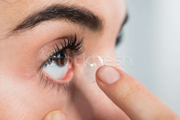Woman Wearing Contact Lens At Home Stock photo © AndreyPopov