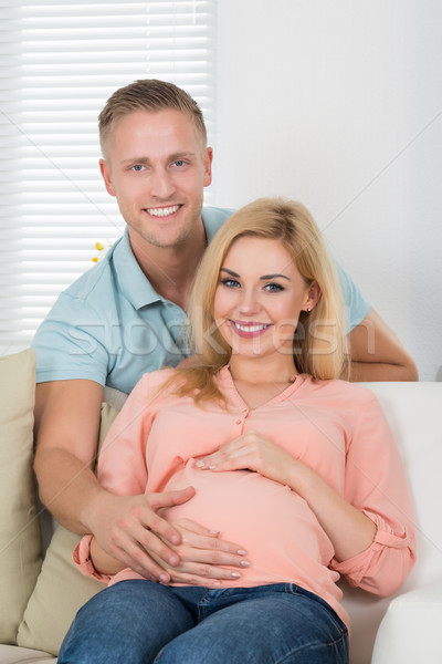 Szczęśliwy para posiedzenia sofa domu portret Zdjęcia stock © AndreyPopov