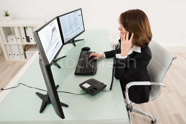 Young Female Stock Market Broker Working On Multiple Computers Stock photo © AndreyPopov