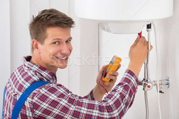 Male Plumber Examining Electric Boiler Stock photo © AndreyPopov