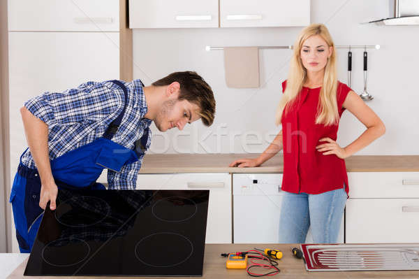Male Repairman Installing Induction Cooker In Kitchen Stock photo © AndreyPopov