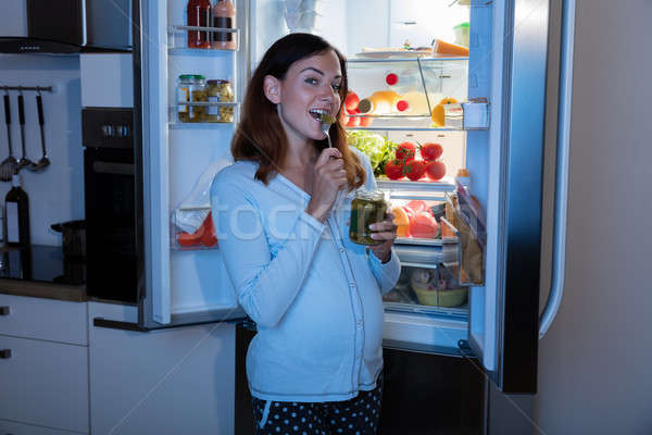 Mulher grávida alimentação cozinha jovem desfrutar jarra Foto stock © AndreyPopov
