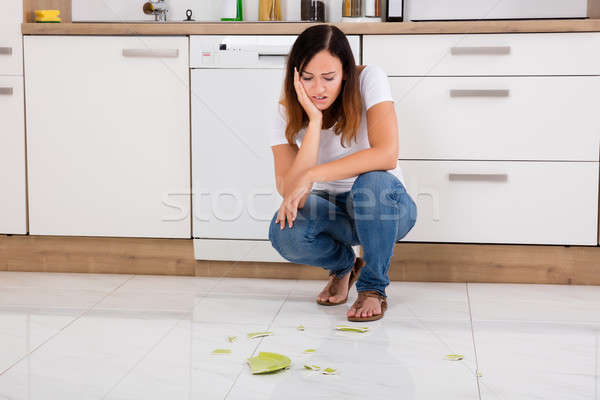 Unhappy Woman Looking At The Broken Plate On Floor Stock photo © AndreyPopov