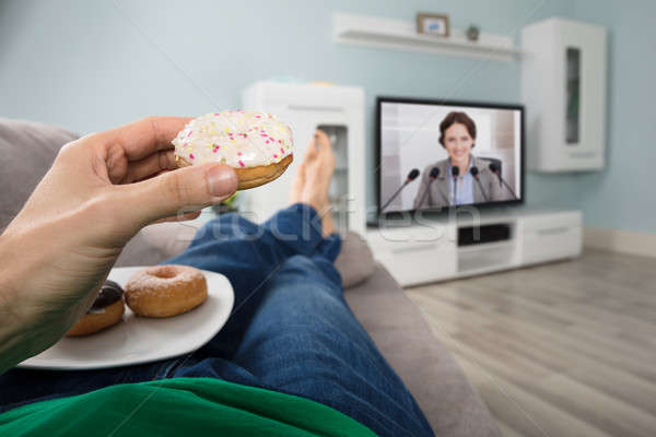 人 吃 油炸圈餅 看電視 家 商業照片 © AndreyPopov