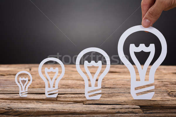 Paper Light Bulbs Arranged In Increasing Order On Table Stock photo © AndreyPopov