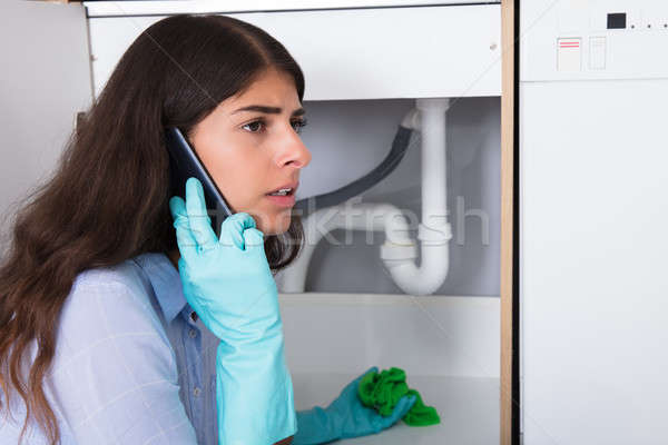 Woman Holding Napkin Under Sink Pipe Leakage Calling Plumber Stock photo © AndreyPopov