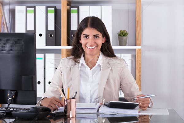 Happy Businesswoman Calculating Financial Data Stock photo © AndreyPopov