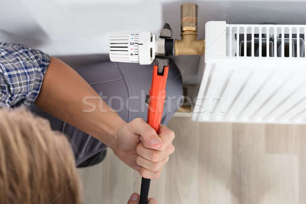 Stock photo: Male Plumber Fixing Thermostat Using Wrench
