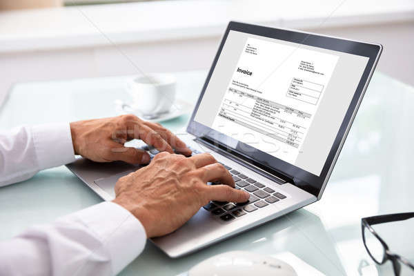 Businessman Checking Invoice On Laptop Stock photo © AndreyPopov