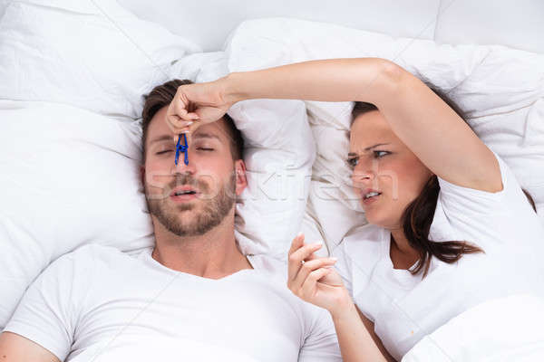 Woman Trying To Stop Man's Snoring With Clothespin Stock photo © AndreyPopov