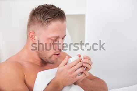 Stock photo: Man with a cold blowing his nose